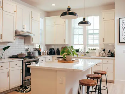 Bright white kitchen with an island and bar stools